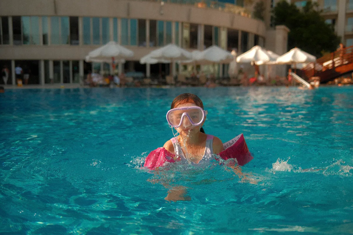 Child practising snorkel skills with a mask in clear shallow water